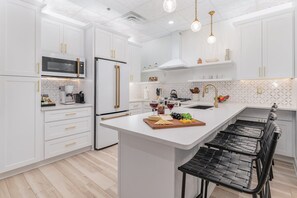 Fully Equipped Kitchen featuring stainless steel appliances, open counter space, and bar seating for 4 guests.