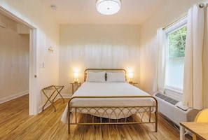 Primary bedroom with direct access to the bathroom. Queen bed, ceiling fan inside the light fixture (called a "fandelier"). Also an individually controlled air conditioner and heater, similar to hotels (called a PTAC).
