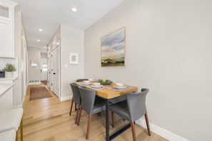 Bright dining space with table, bar seating, and pantry for storage.