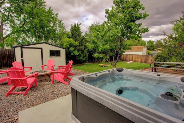 The backyard has a hot tub and is fully fenced, with a grassy area for kids and pets!
