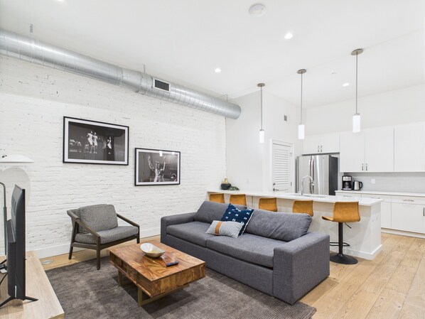 Open-concept living area featuring cozy furnishings, smart TV, and a sleeper sofa.