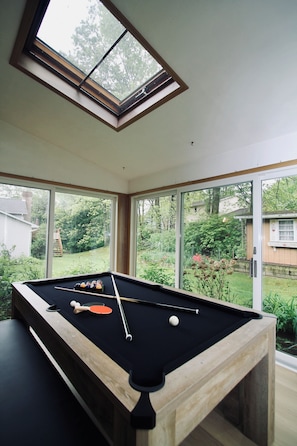 This spacious three-season room is the ultimate spot for gathering and unwinding. At its heart is a large, multi-use table that easily transforms to accommodate a variety of activities—challenge your group to a game of pool or ping pong, enjoy a cozy family-style meal, or simply relax with drinks and conversation.
Surrounded by sliding screened doors, the room brings in fresh ...
