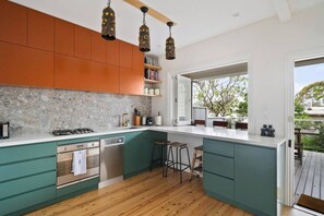 Cook with ease in the fully renovated kitchen, complete with forest green cabinetry and stone finishes.