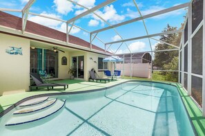 Step into the refreshing screened-in pool with built-in entry steps, surrounded by a spacious patio and lounge seating—ideal for fun-filled family days or quiet evenings outdoors.