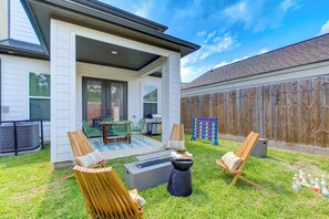 Backyard patio with plush sets, fire pit, and games
