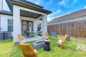 Backyard patio with plush sets, fire pit, and games