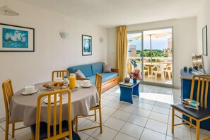 Enjoy a cozy meal in this inviting living and dining area, featuring a comfortable sofa and easy access to the balcony. 