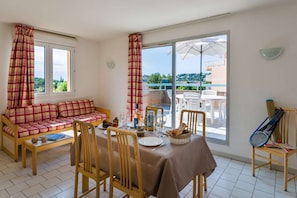 A bright and airy dining area with direct access to the balcony is perfect for enjoying meals from a view. The cosy seating arrangement and large windows create a welcoming atmosphere filled with natural light.