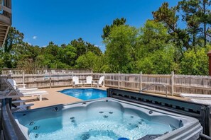 Dive into paradise at Yellow Lotus's outdoor entertaining area, featuring a fenced private pool with inviting pool loungers, a bubbling hot tub, and a sizzling gas grill for al fresco feasts. Enjoy endless fun with the playground and outdoor games. 