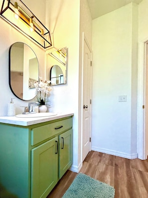 The bathroom features a tub-shower combination,vanity sink,toilet and hairdryer.