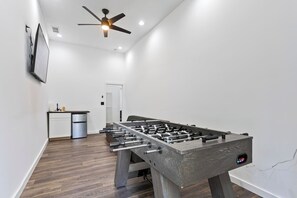 Get ready for the ultimate hangout spot! Your entertainment room is equipped with everything you need – from a sink and chiller for refreshments, to a smart TV and foosball table for non-stop fun