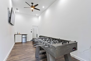 Get ready for the ultimate hangout spot! Your entertainment room is equipped with everything you need – from a sink and chiller for refreshments, to a smart TV and foosball table for non-stop fun