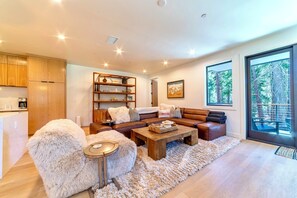 Living room has powder room and a private deck nestled in the trees.