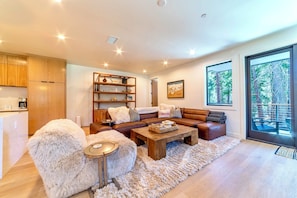 Living room has powder room and a private deck nestled in the trees.