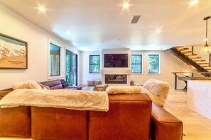 Living room has large TV w/ smart features and ambient gas fireplace.