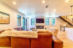 Living room has large TV w/ smart features and ambient gas fireplace.
