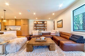 Living room has oversized comfortable furnishings including a leather sectional couch.