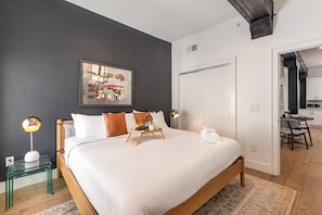 The primary bedroom features a king bed, closet, dresser, and a stylish accent wall for a cozy, curated feel.