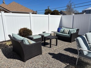 Private backyard with plenty of seating, umbrellas, outdoor shower, dining table