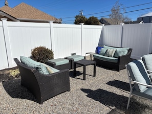 Private backyard with plenty of seating, umbrellas, outdoor shower, dining table
