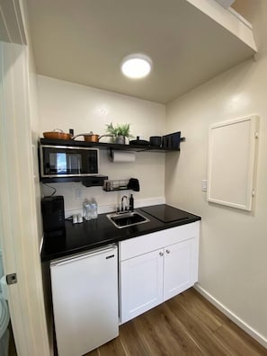 Kitchenette with microwave, cooking utensils, and stove top