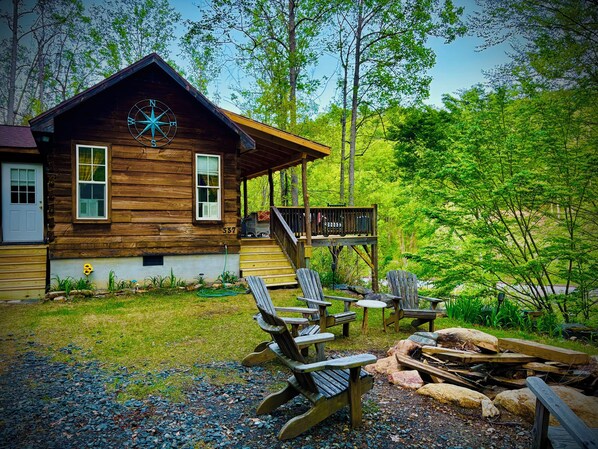Front of the cabin with the outdoor fire pit riverfront.