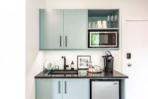 Prepare light meals or morning coffee in the stylish kitchenette featuring a mini fridge, microwave, and coffee!.