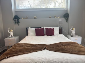 Bedroom Oasis: Modern room with quirky astronaut lamps and plush bedding in a vibrant setting!
