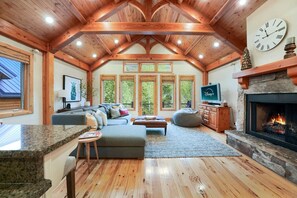 Spacious and inviting living room with plenty of comfortable seating, a cozy sofa, and large windows that fill the space with natural light.
