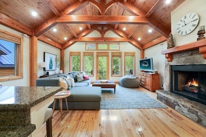 Spacious and inviting living room with plenty of comfortable seating, a cozy sofa, and large windows that fill the space with natural light.