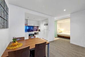 Modern living space with dining, bedroom, and kitchen in view.