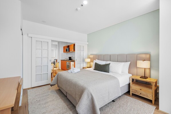 This studio apartment offers a comfortable and practical layout, featuring a large bed,  and convenient sliding doors that can separate the bedroom from the living area.