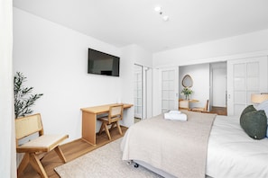 This bright and inviting room offers a comfortable bed, a dedicated workspace, and a relaxing ambiance. Perfect for your next getaway!