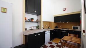 Cook like a local in this vintage-modern kitchen with checkerboard floors, sleek black cabinetry, and all the essentials to prepare a hearty Portuguese meal. #Kitchen #FullyEquipped #HolidayRental