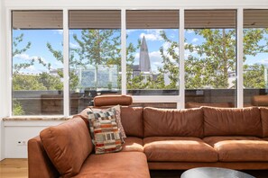 Wake up to breathtaking city views and enjoy the ultimate comfort in this stylish penthouse with a spacious leather sectional sofa.