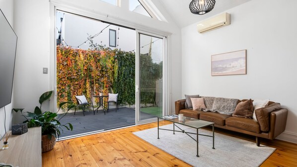 Light and bright living with split system. Floor to ceiling glass doors that open up to private courtyard