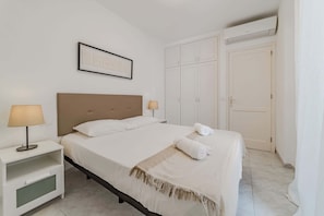 Peaceful Bedroom with Fresh Linens, AC, Plenty of Storage & Courtyard Access.