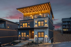 Evening rooftop view with dramatic sky and cozy lighting.
