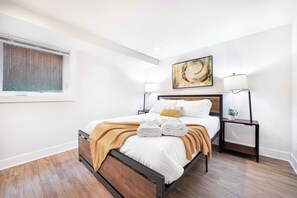 A queen bed wrapped in soft textures + warm lighting for nights of pure calm.