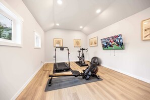 Row, cycle, sprint, or stretch with a rowing machine, bike, treadmill, yoga mat, and stability ball—plus a TV to stream workouts or zone out post-sweat.