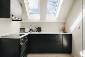 Fully equipped kitchen featuring sleek cabinetry and bright natural light.