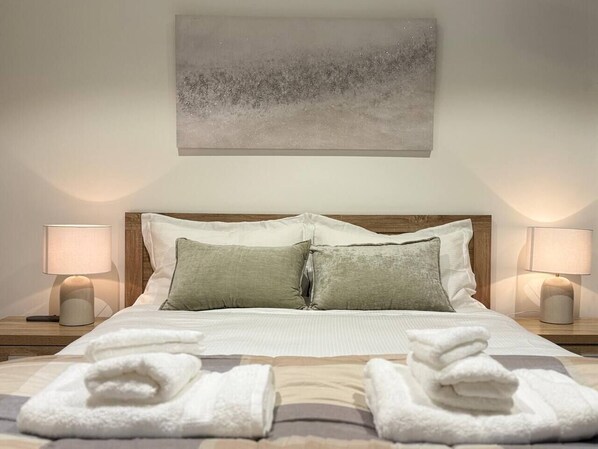 Queenbed with hotel quality bedding and towels. Wireless charging pad