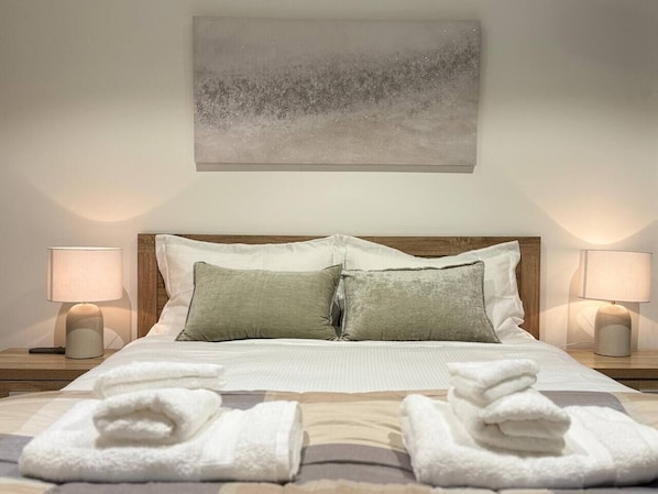 Queenbed with hotel quality bedding and towels. Wireless charging pad