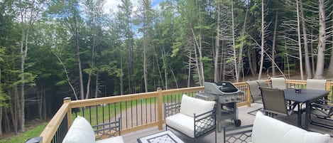 Large deck with seating and a gas grill.