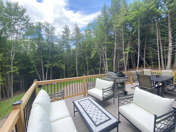 Large deck with seating and a gas grill.