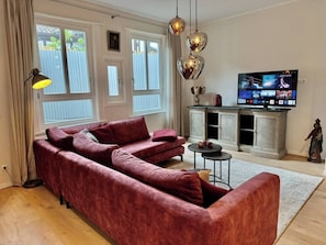 Große Couch, Smart-TV & Vintage-Sideboard – ideal zum Entspannen nach einem erlebnisreichen Tag.
