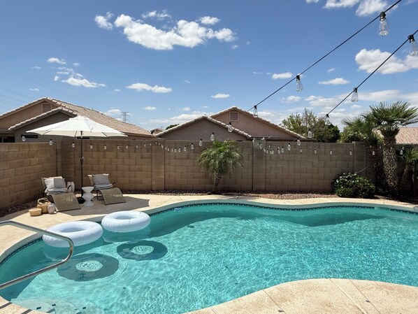 Sun heated pool with lounge chairs and pool lights