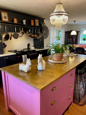 Handmade kitchen with expansive kitchen island topped with antibacterial copper!