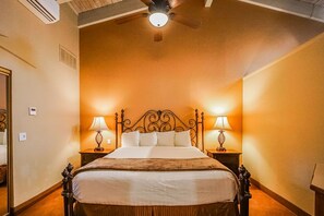 Experience cozy relaxation in a charming bedroom featuring a plush king bed and warm lighting, perfect for a desert getaway.