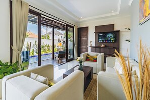 Cozy downstairs lounge with smart TV and sofas at Griya Purnama